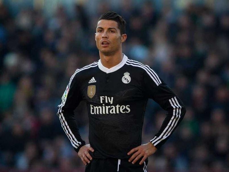 Cristiano Ronaldo wearing black Real Madrid kit lifting Champions League trophy